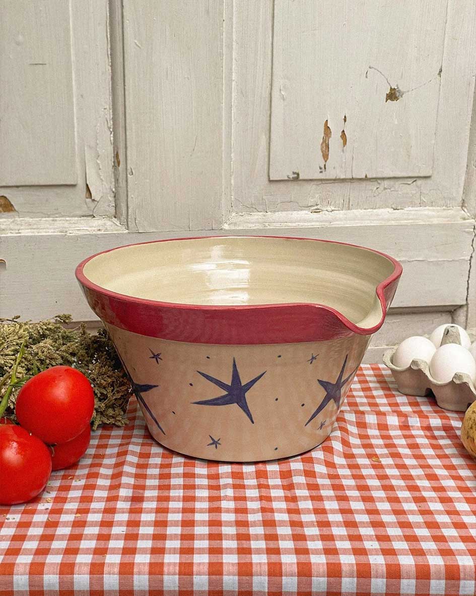 Handcrafted Spanish ceramic large mixing bowl with blue star pattern and red rim, displayed with fresh tomatoes on orange gingham tablecloth