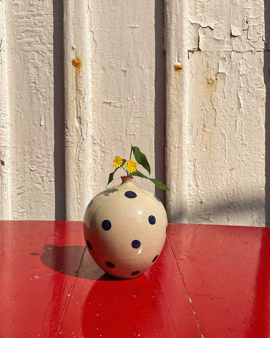 Handcrafted Spanish ceramic medium vase with blue polka dots, featuring yellow wildflowers on vibrant red surface